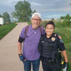 A Boulder Police officer posing for a photo with a community member on a multi-use path
