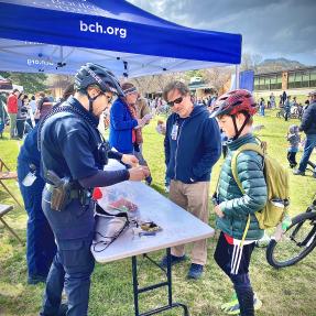 Boulder Police officers at a table talking about bike safety with community members 