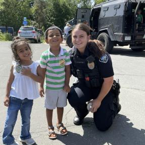 Boulder Police Officer kneeling down with two children