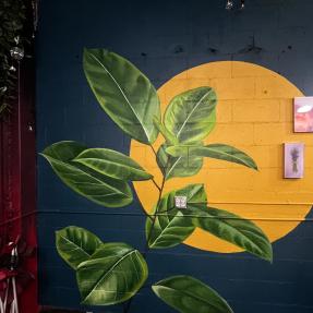 Realistic leaves in front of a bright yellow circle 