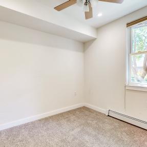 Other bedroom view with fan and window