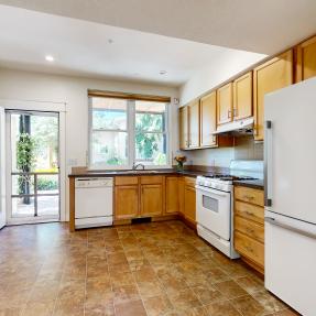 Full kitchen view and looking out to the window and glass door