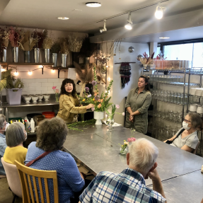 Older adults taking a flower arranging class. 