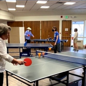 Older adults playing table tennis. 