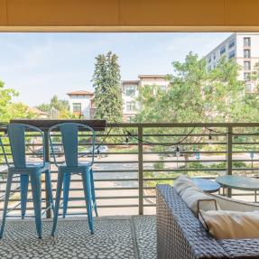 Patio view looking out to home buildings blue steel chairs