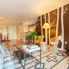 Other side livingroom view painted tree wall and large floor carpet