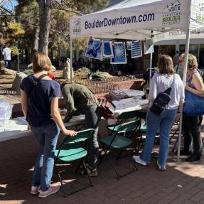 Community members gathering around tables downtown