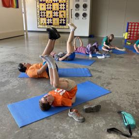 Amico campers doing exercises on a mat indoors