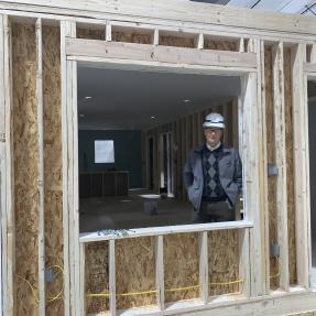 Kurt Firnhaber looking out of a window opening in a partially constructed home in the Boulder Mod factory.