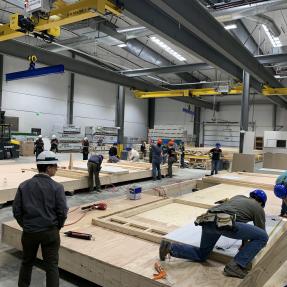Student and volunteer workers working on modular homes in the Boulder Mod factory.