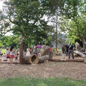Nature play area log features and colorful signage with children