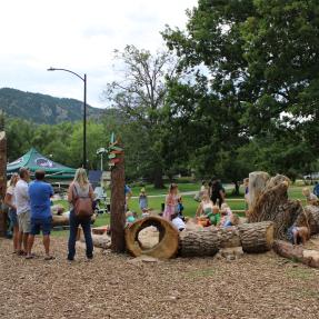Nature play area log tunnel feature with children