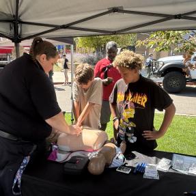 Firefighter showing a kid how to do CPR