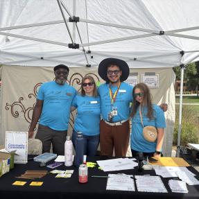 Four people standing behind a table smiling