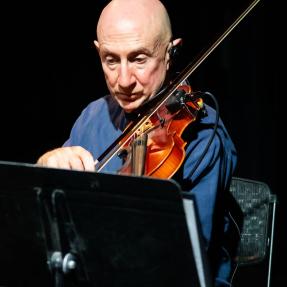 Violinist playing during the Motus Elevate Boulder monologue performance.