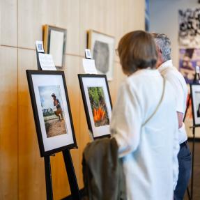 Community members viewing photographs from Elevate Boulder participants in the Dairy Arts Center library.