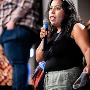 Audience member asking a question during the Elevate Boulder monologue performance at Motus Theater.