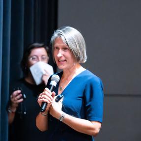 Elizabeth Crowe speaking on stage during the Elevate Boulder monologue performance at Motus Theater.