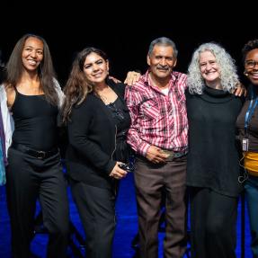 Group of six Elevate Boulder participants posing on stage after their monologue performance at Motus Theater.