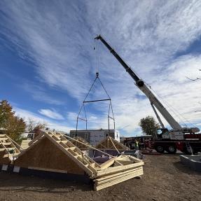 First section of modular home being lifted off the truck. 