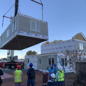 Last section of the modular home lowing into place. 