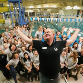 Parks and rec staff standing in front of a pool at a rec center