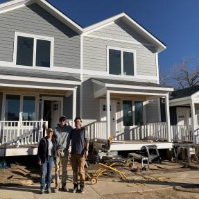 Volunteers posing in front of the first three foundation-built Ponderosa homes in May 2024. 