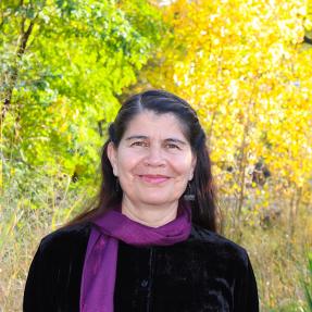 Person standing with a fall foliage background
