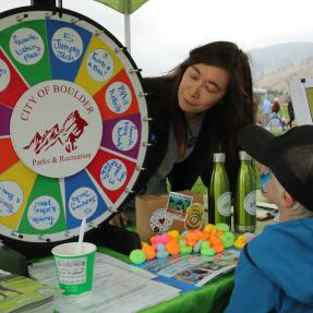 City employee interacting with a young community member at What's Up Boulder