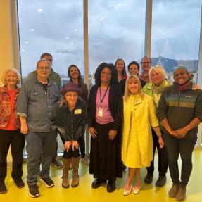 Grupo de personas racialmente diversas de pie juntas y sonriendo