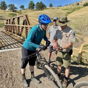 Volunteer Trail Guide providing information to a mountain biker.