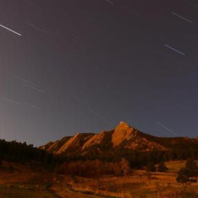 Boulder Flatirons under a starry night sky