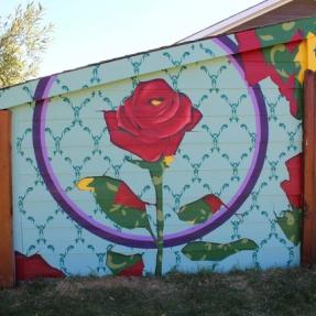 Mural of a rose on the side of a fence