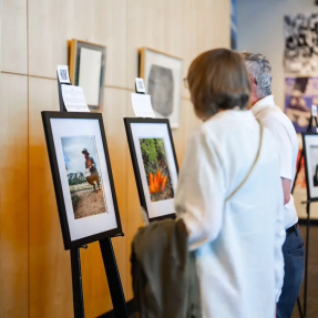 Woman and man viewing a gallery of images taken by Elevate Boulder participants.