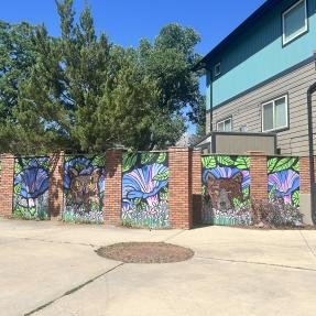 Mural of bears and flowers on the side of a fence