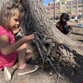 children building and playing with sticks in civic area
