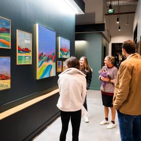 Attendees of an art exhibition admiring work on walls