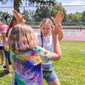 Two campers high fiving at the color run