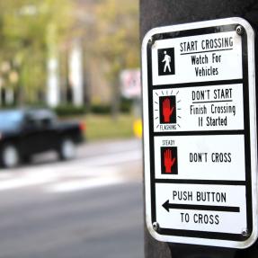 Crosswalk sign with instructions to push button