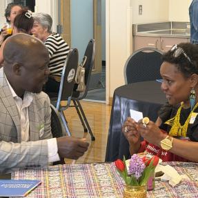 City council member and community organization leader, sitting at a table in discussion