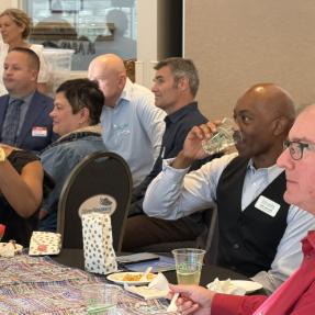 left profile of multiple tables of event participants including city staff, elected officials and partner organizers