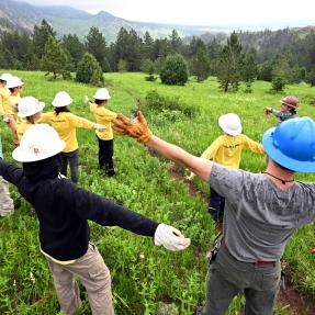 Group of teens pausing to enjoy the rain while working outdoors