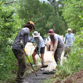 Volunteers spread gravel on South Mesa trailhead trail during National Trails Day.