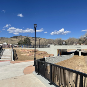 multi-use path and bike/pedestrian underpass beneath road; stairs lead up to road
