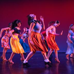 Dancers in colorful outfits performing on stage