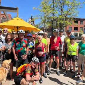 Group of older adults posing for the camera on Pearl Street during a bike event. 