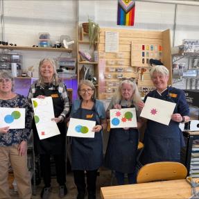 Five older adult women showing off their artwork made in the city's Makerspace. 
