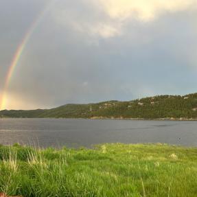Barker Reservoir with a rainbow on a cloudy day.