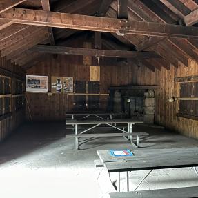 Inside Green Mountain Lodge, a rustic building with picnic tables.