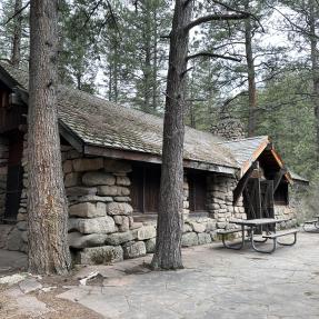 Green Mountain Lodge, stone building surrounded by pine trees.